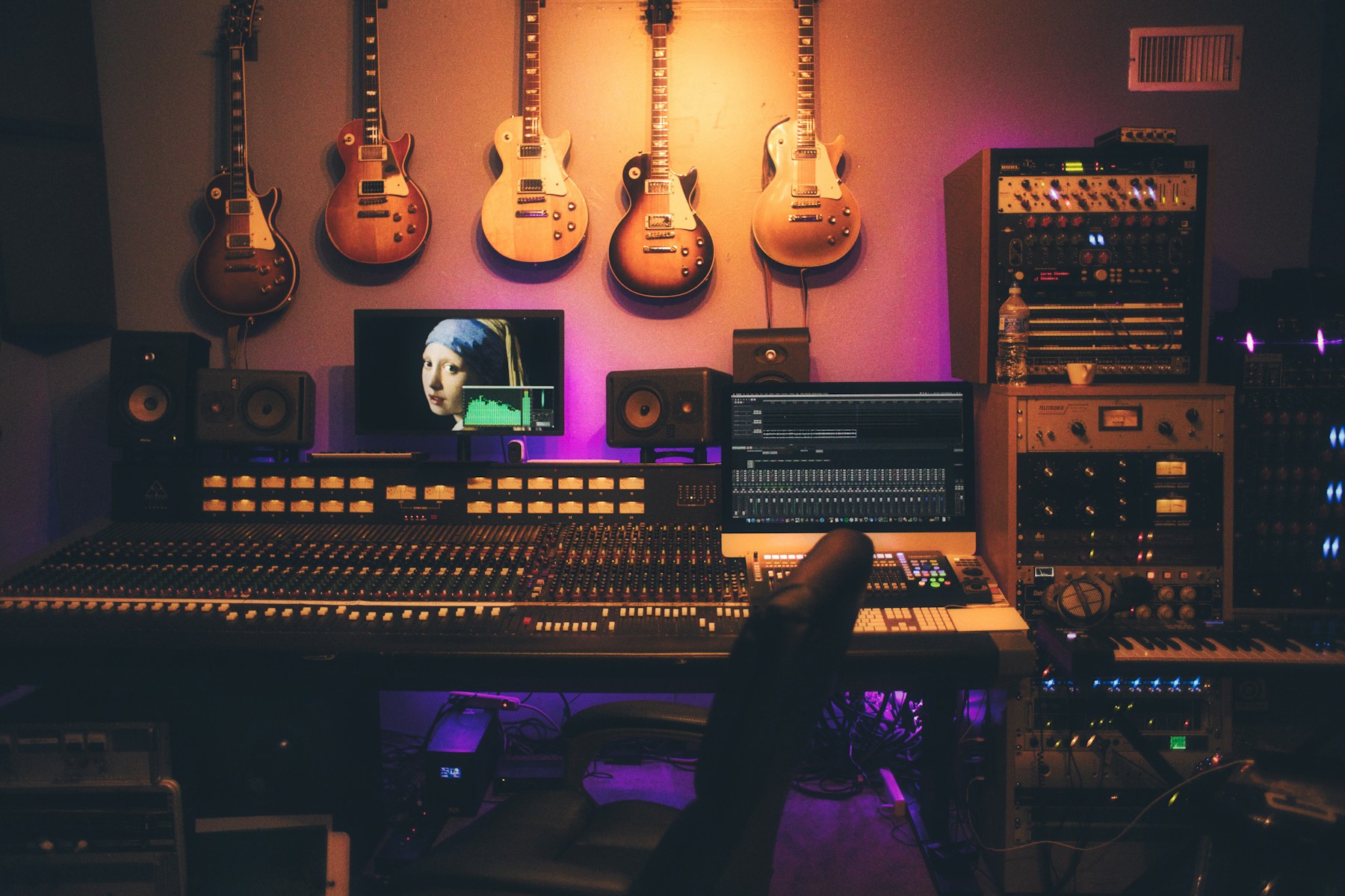 Illustrative studio with guitars, monitors and a mixing desk